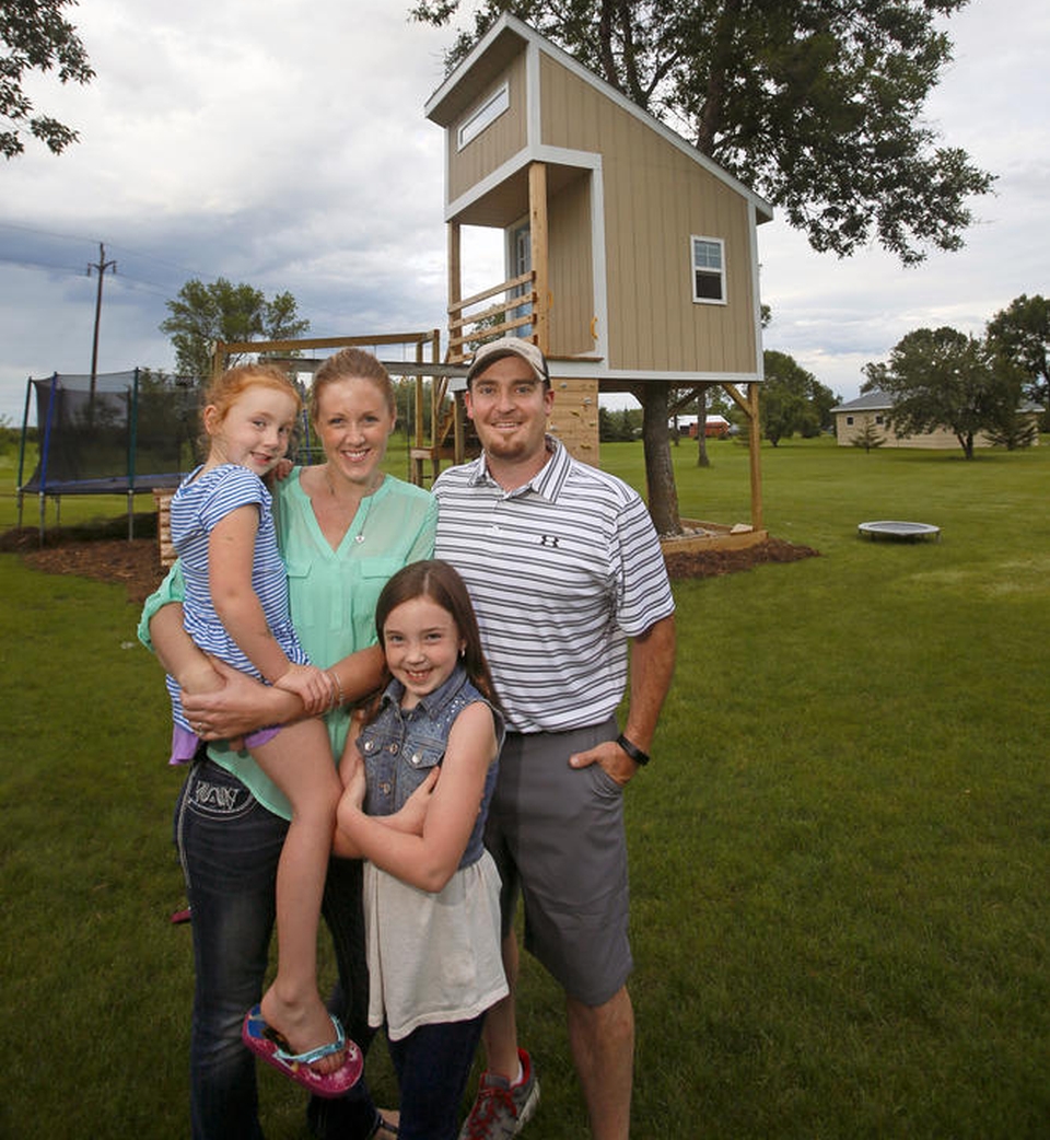 The complete family outside their newly built treehouse