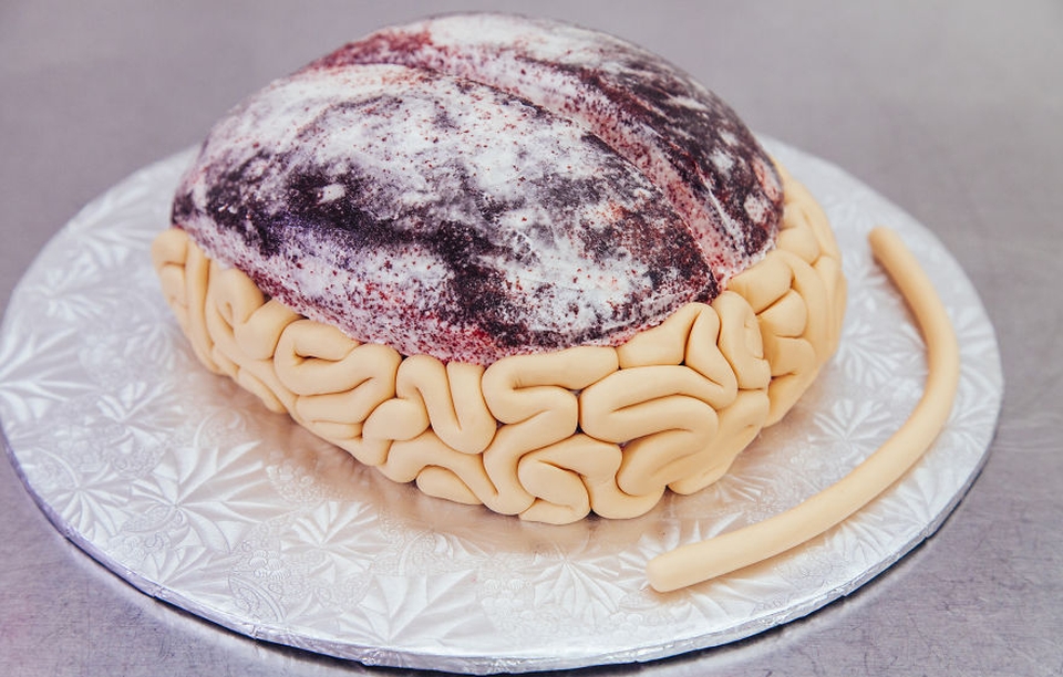 Covering the cake with flesh-colored fondant to give a real brain look.