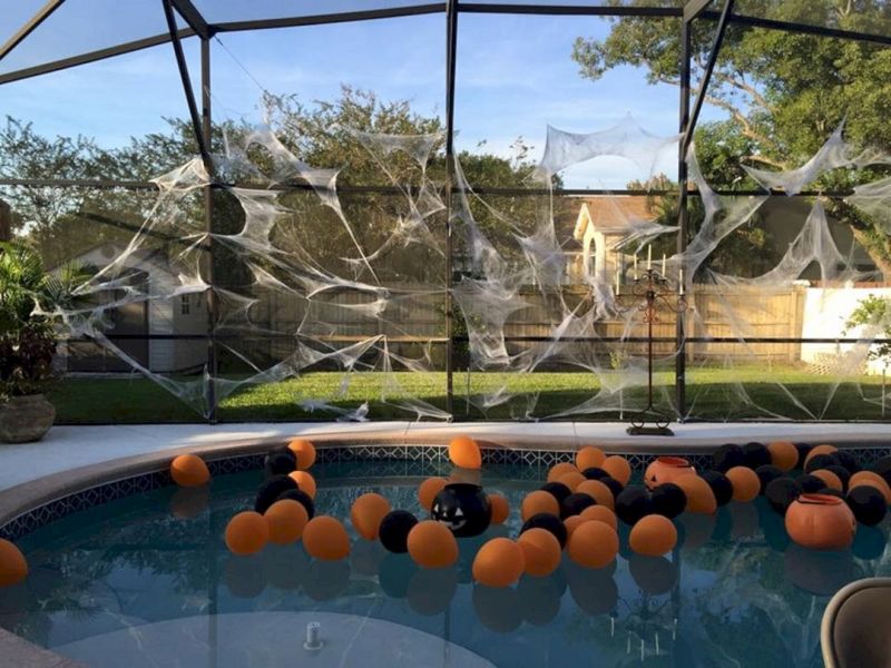 orange and black Balloons for Halloween decor in the pool   