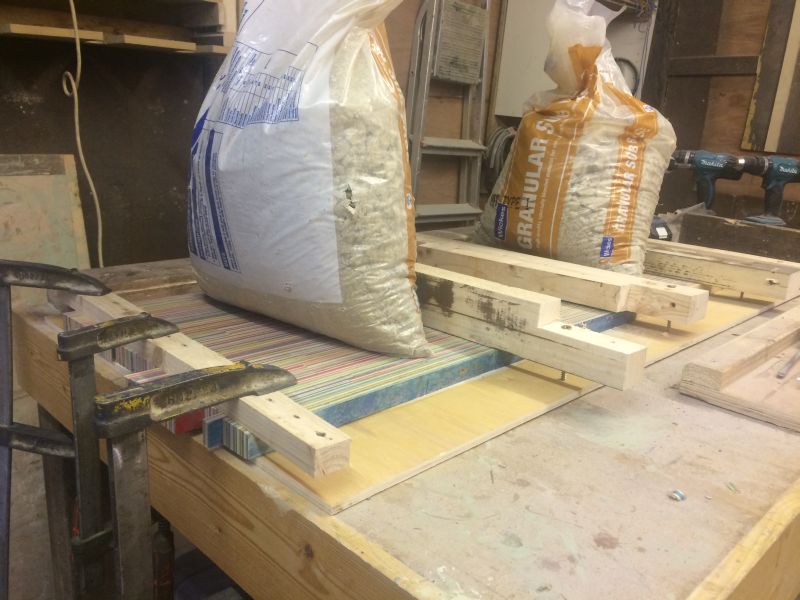 Pressure and glue are used to join two wide lengths into tabletop 