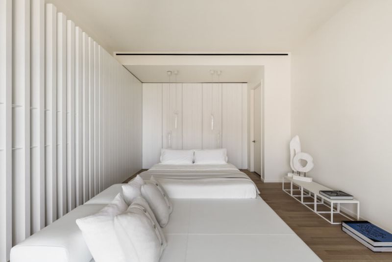 Two sides of bedroom made with vertical white stained oak panels 