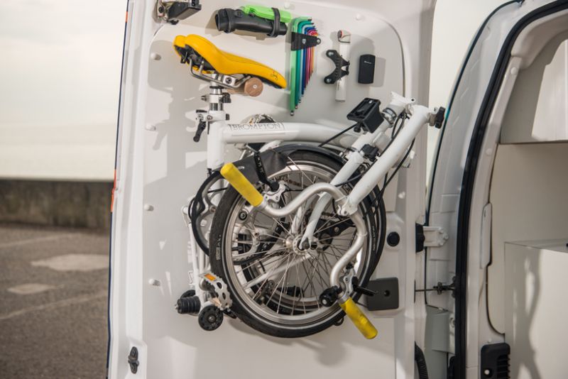 A folding Brompton bike mounts on the rear door for easy access 