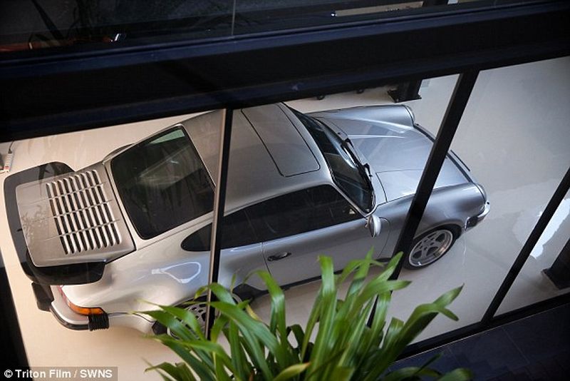 Thai man builds glass elevator in lounge to display his Porsche cars