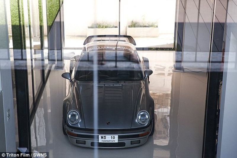 Thai man builds glass elevator in lounge to display his Porsche cars