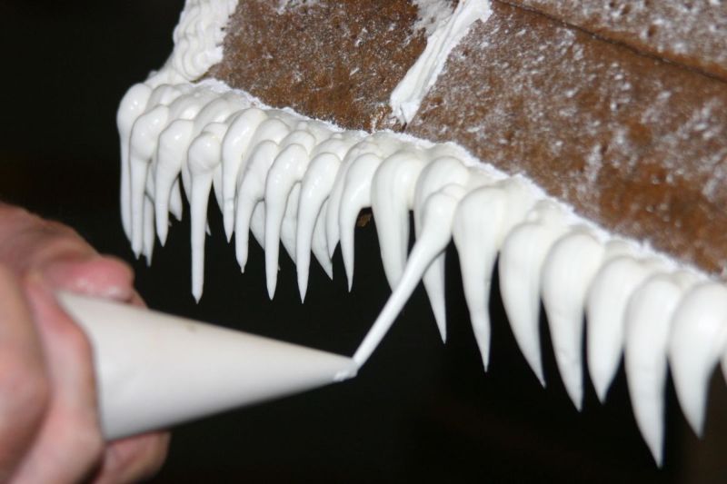 A number of icicles hanging from the eaves of the house