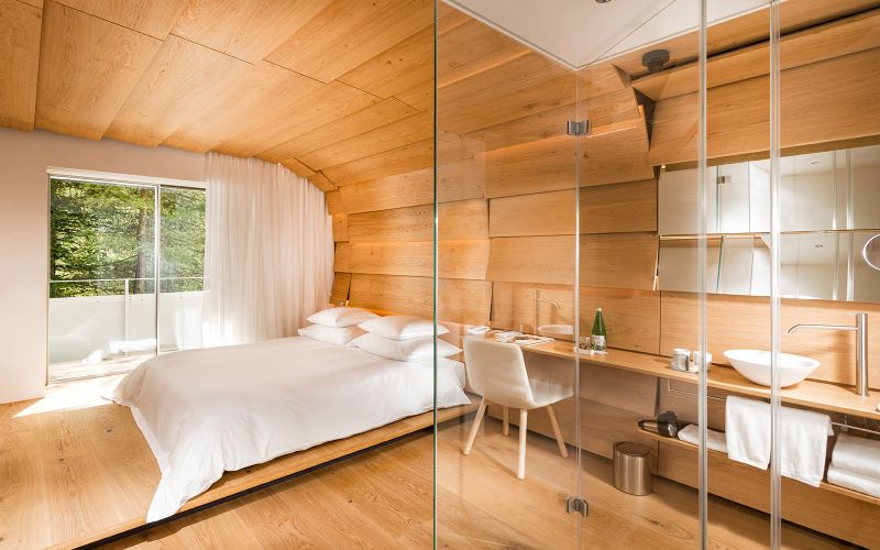 Hotel 7132’s wood and stone guest suites feature tinted glass shower