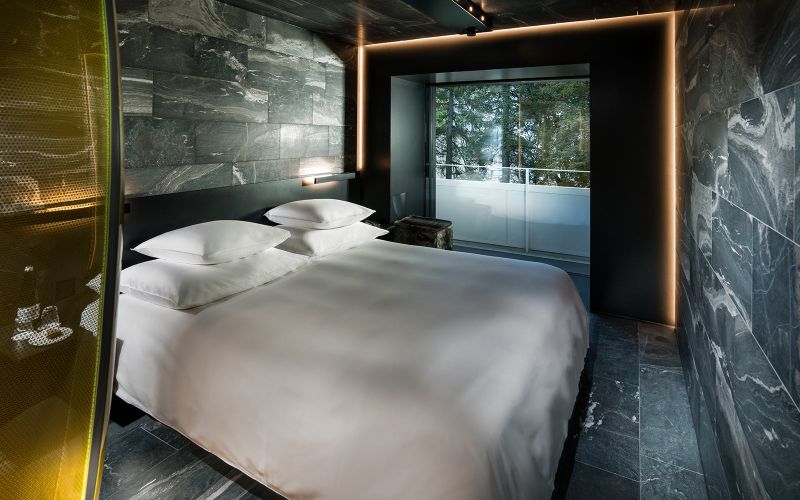 Hotel 7132’s wood and stone guest suites feature tinted glass shower