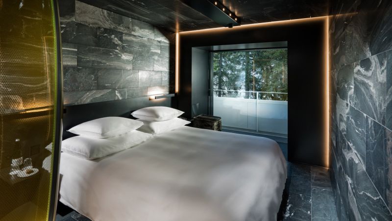 Hotel 7132’s wood and stone guest suites feature tinted glass shower