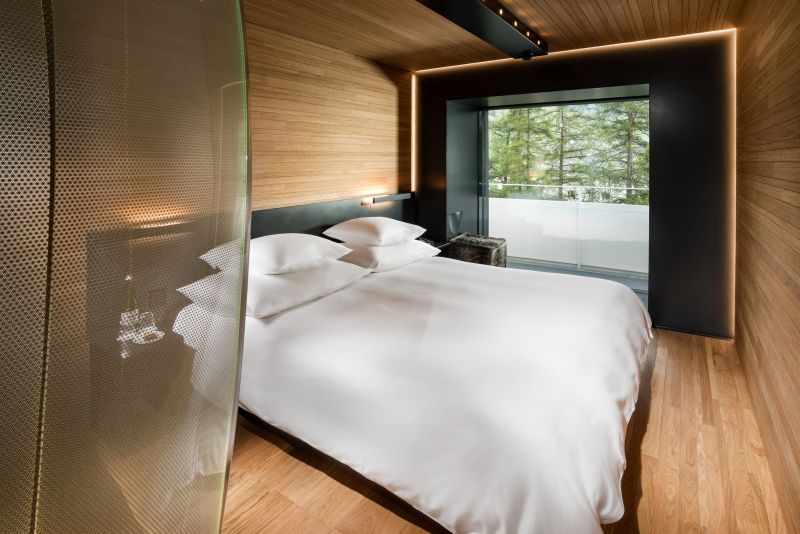 Hotel 7132’s wood and stone guest suites feature tinted glass shower