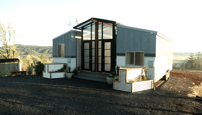 Ohana tiny house features a patio between two trailers