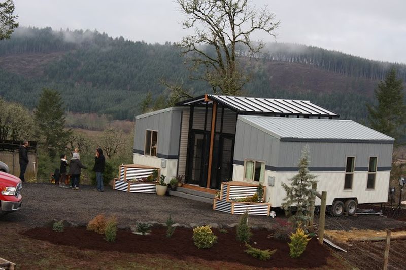 Ohana tiny house features a patio between two trailers