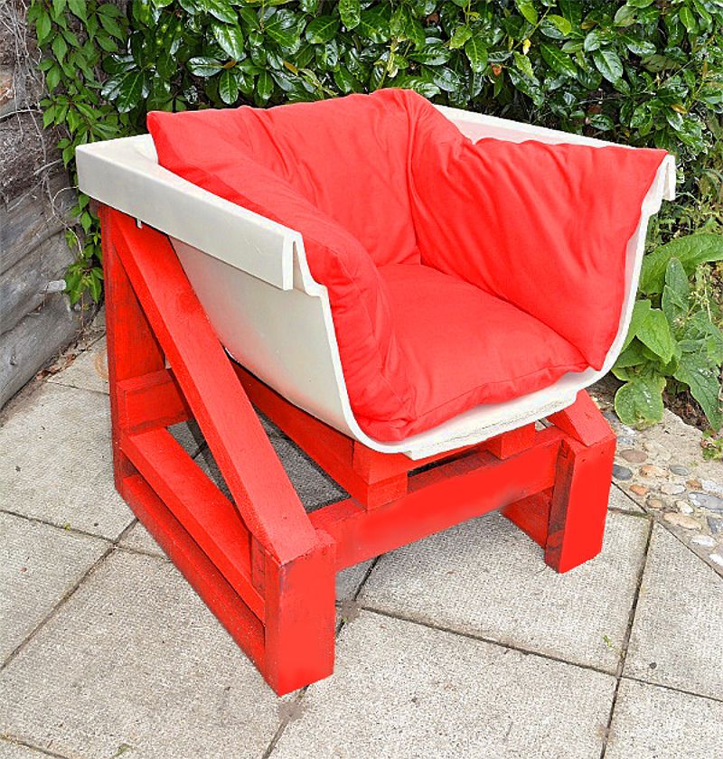 Old bathtub into a garden chair with cushions and wood frame 