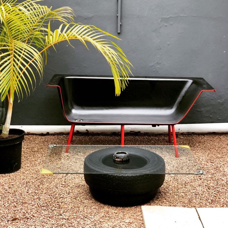 Old bathtub into comfy black and red sofa with thin legs 