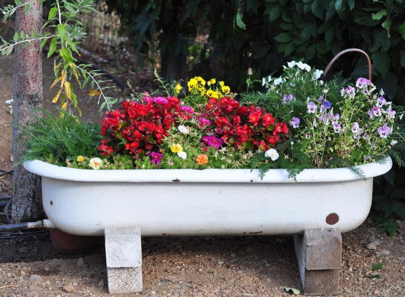 Old bathtub into a planter with wooden stand 