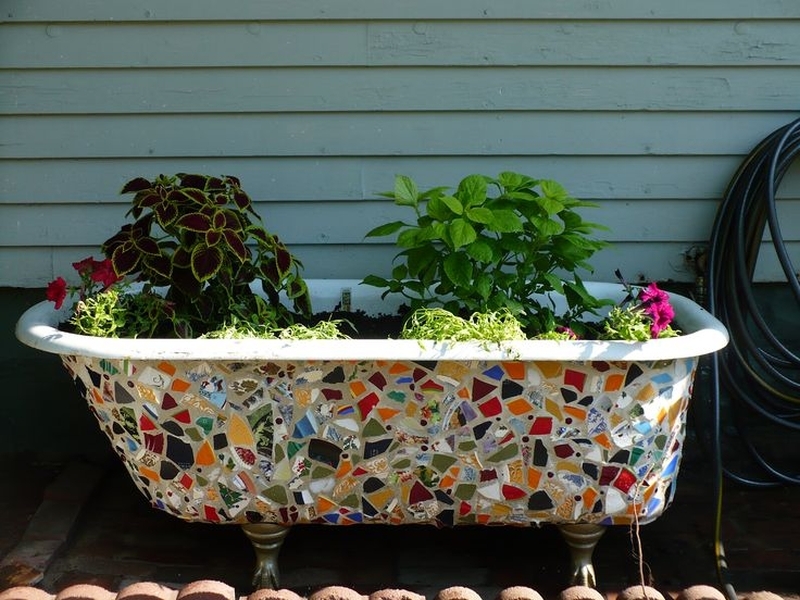 Old Bathtub as planter with mosaic design on outer surface  