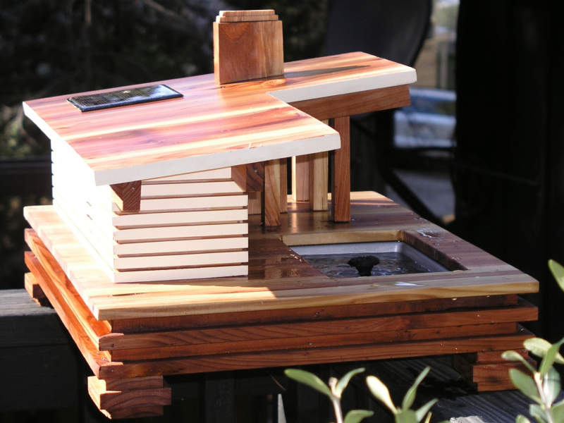 This mid-century modern birdhouse features a solar-powered bird bath 