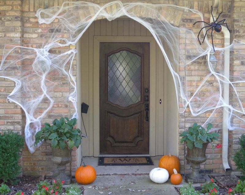 front door decor with spiderweb and spider props 