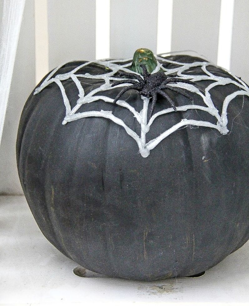 DIY hot glue spider webs over pumpkin