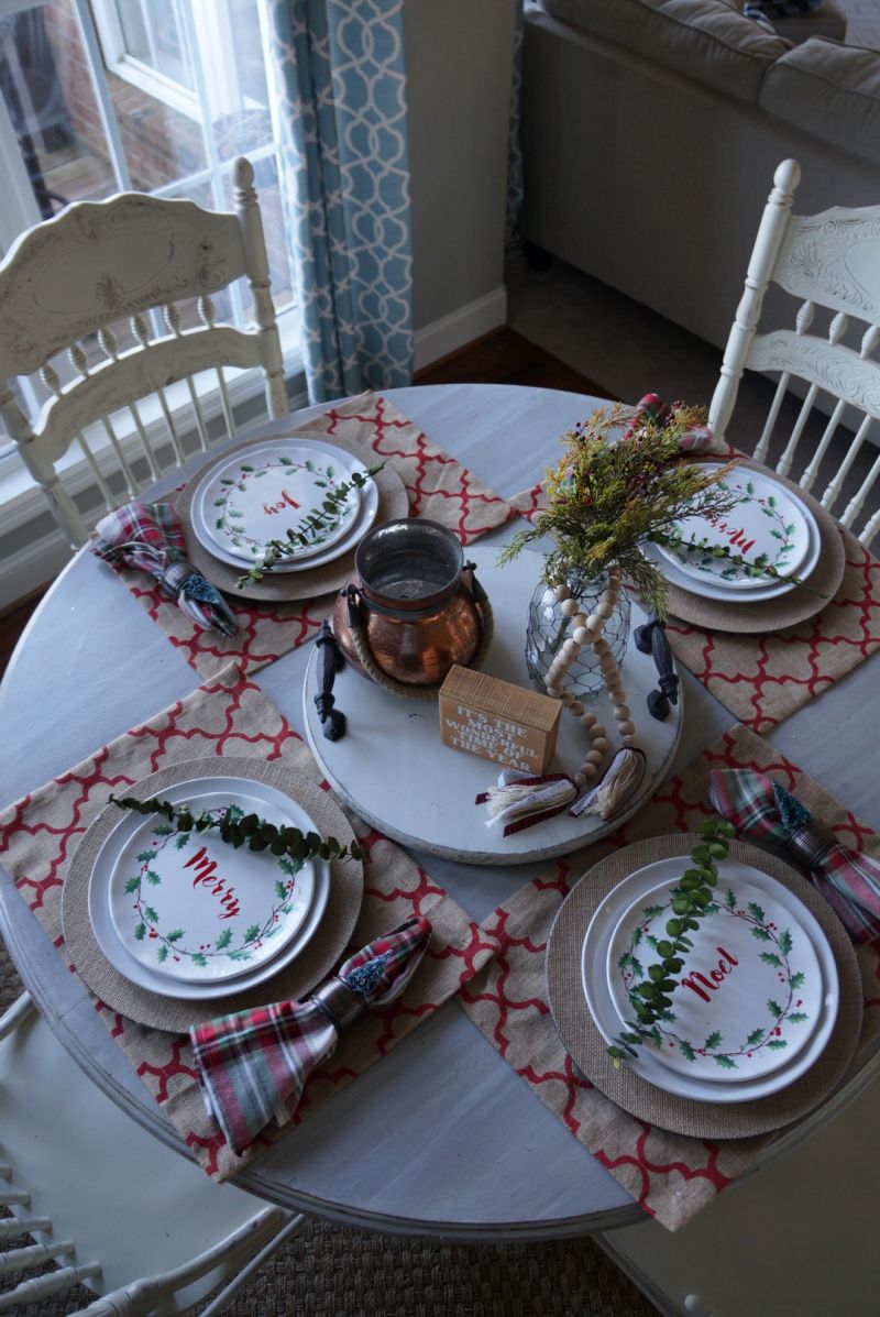 casual Christmas dining table with holiday themed plates, eucalyptus and plaid napkins