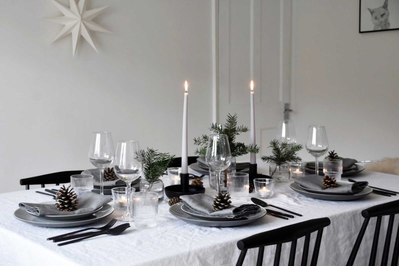 minimalist Christmas dining table using fir, candles, and pinecones