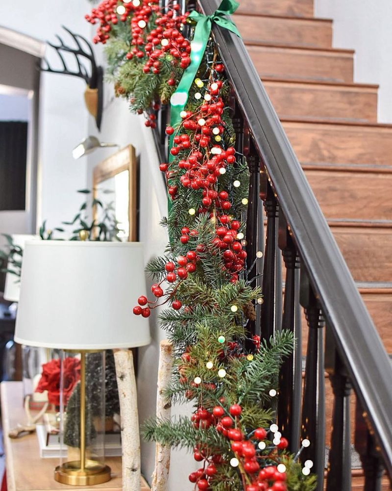 Greenery and red berries for Christmas staircase decor 