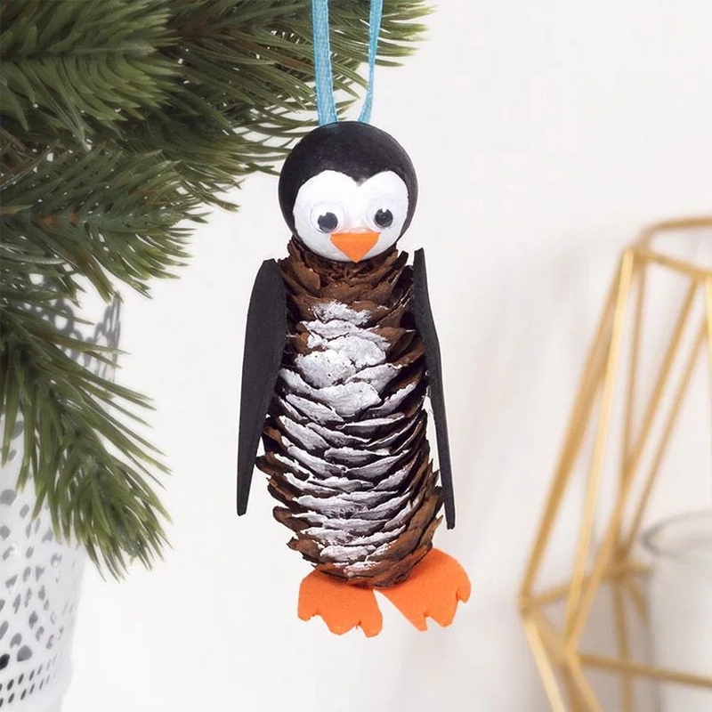 Cute pine cone penguin ornament to hang on Christmas tree