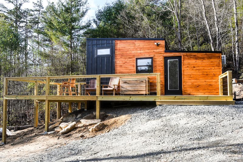 Industrial Tiny Cabin Sits Next To Icy Blue-Green Pond in North Carolina