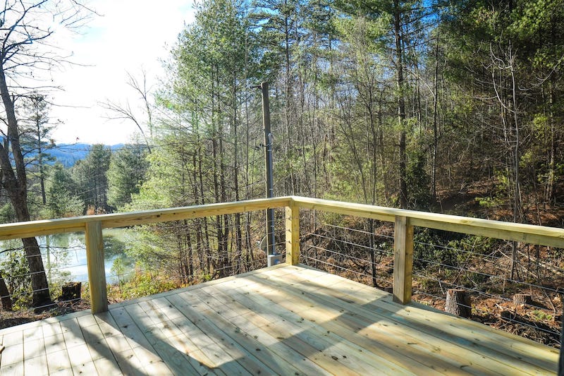 Industrial Tiny Cabin Sits Next To Icy Blue-Green Pond in North Carolina