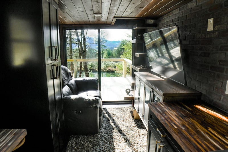 Industrial Tiny Cabin Sits Next To Icy Blue-Green Pond in North Carolina