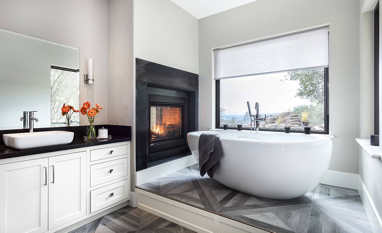 Minimal bathtub, fireplace and neutral color scheme turn the bathroom in a relaxing escape