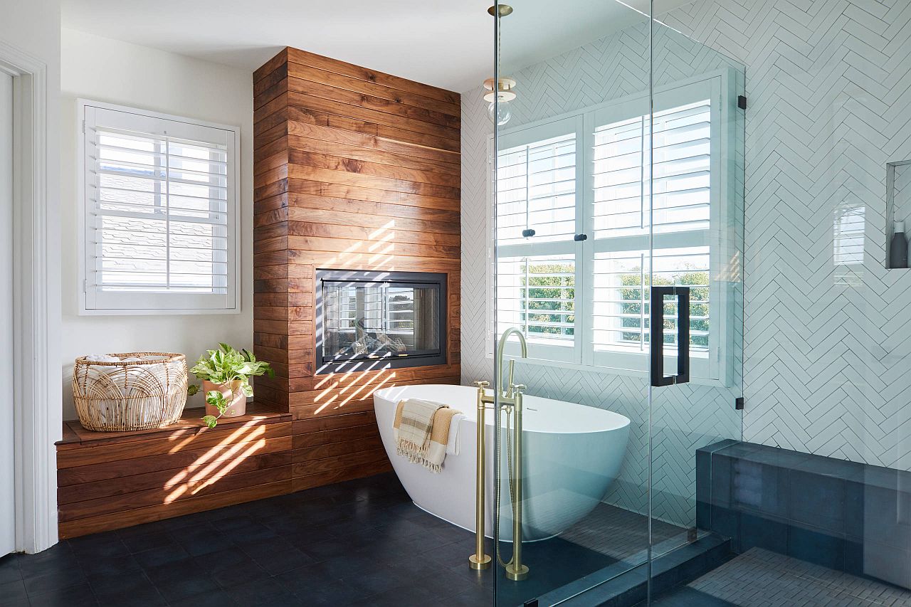 Wooden surround around the fireplace along with the bench create a relaxing bathroom