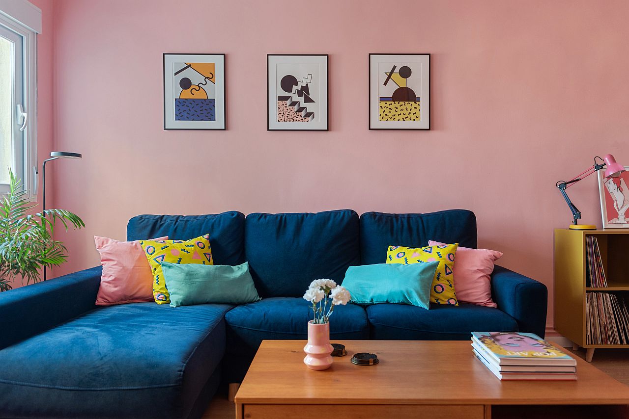 Bold blue couch coupled with pink walls in the living room with limited square footage