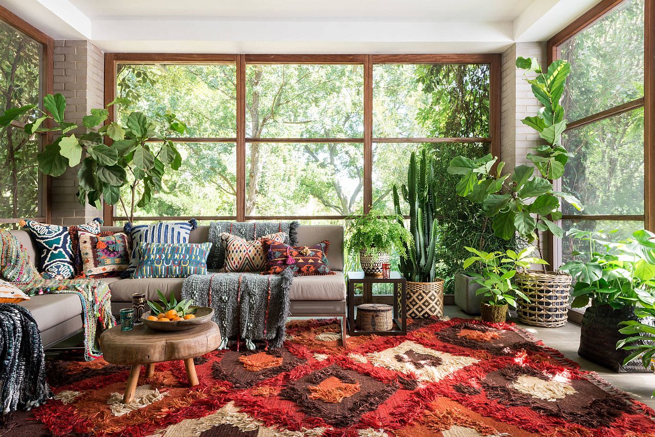 Greenery coupled with a vivacious rug in the sun-filled living space