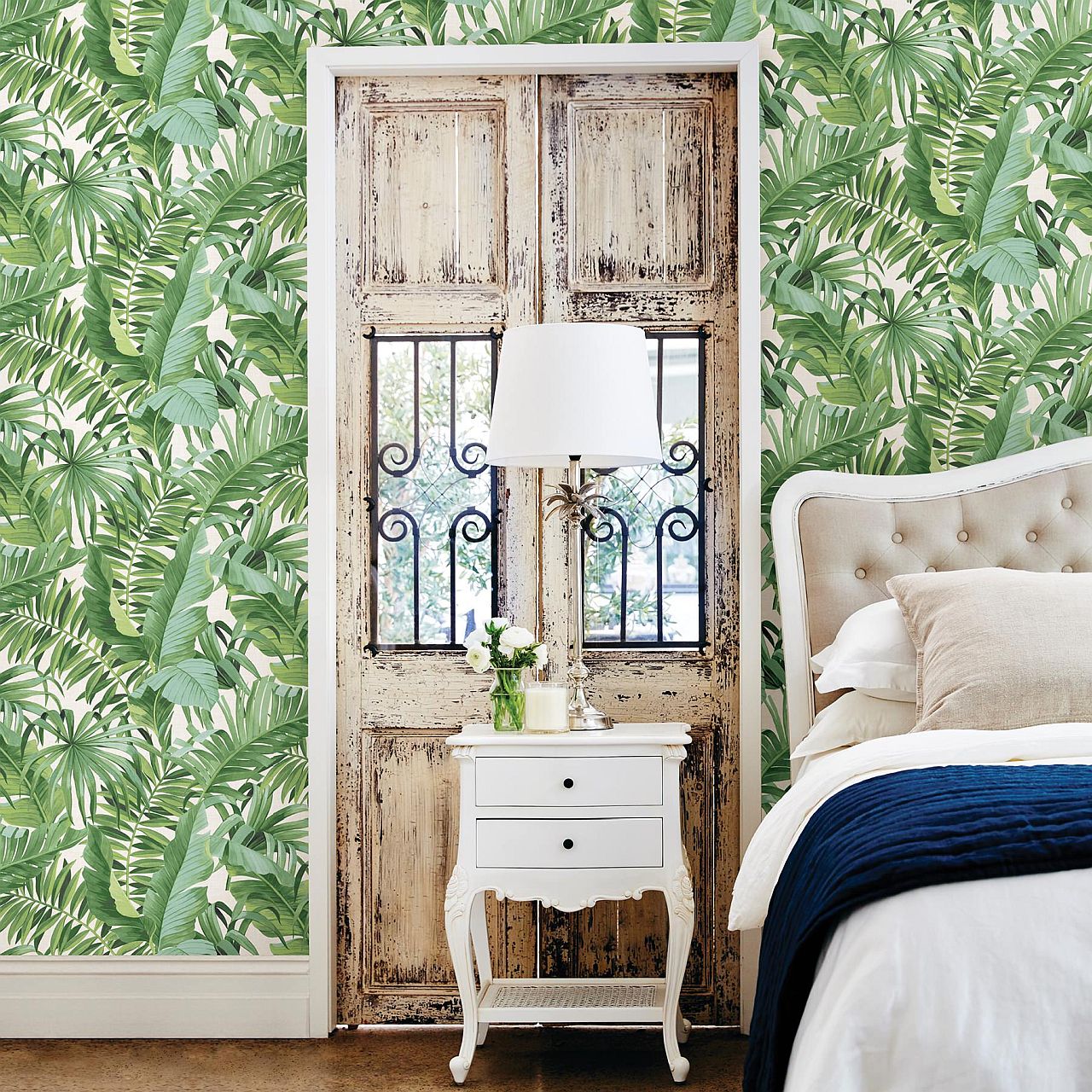 Wallpaper in green with leafy motif makes a big impression in this small bedroom