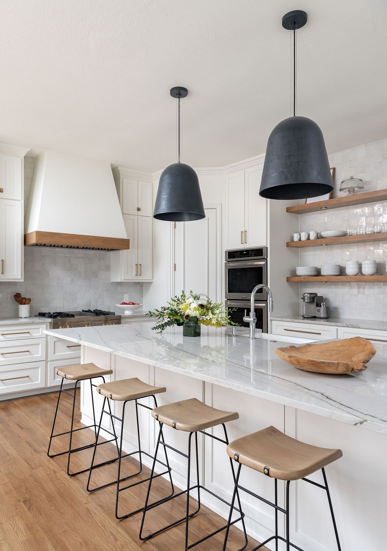 Large pendants usher matte black into the white, bright kitchen