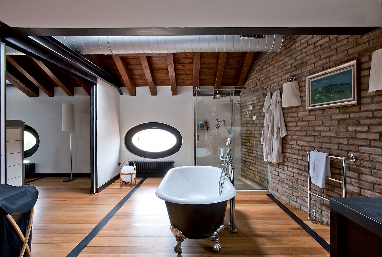 Modern industrial style bathroom with exposed brick wall and duct pipes