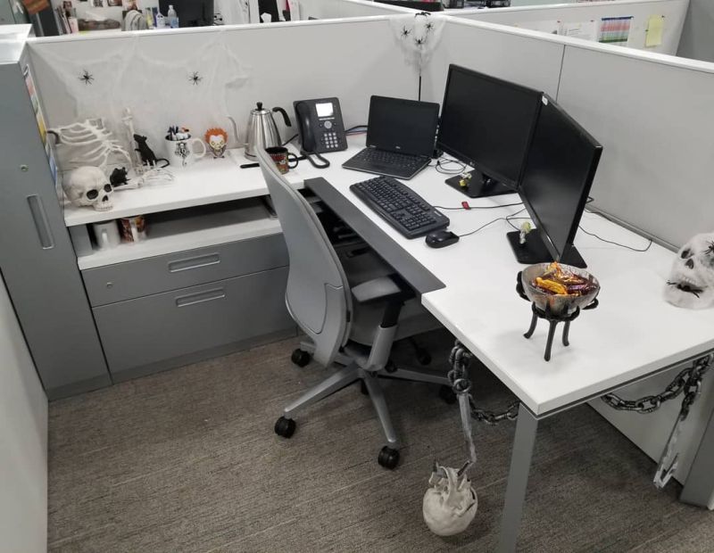 office cubicle with a skeleton hand candy bowl stand and boney props on the desk