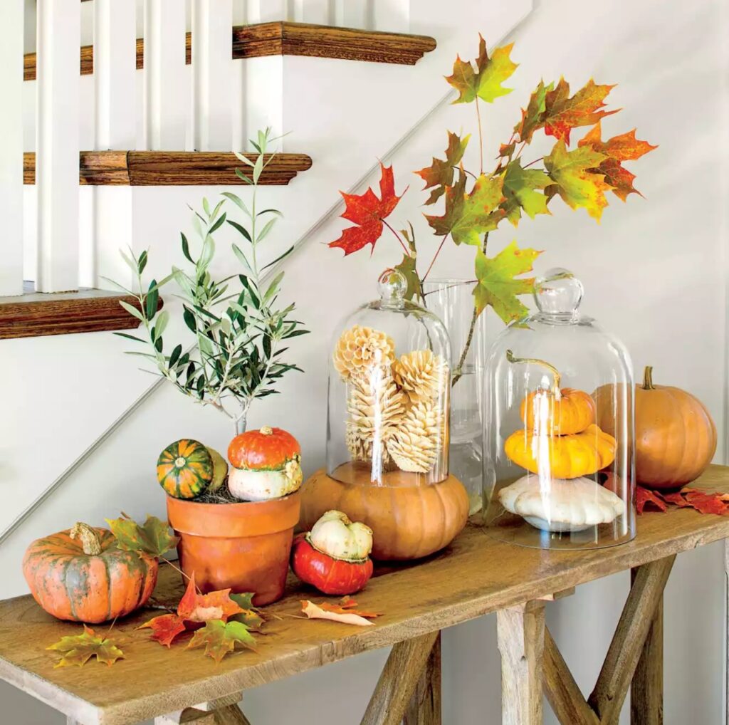 under stairs fall decor with pumpkins and cloche  