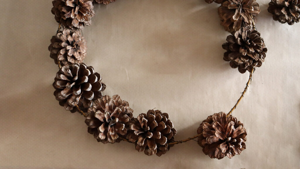 Tie-pinecones-onto-wreath-with-wire