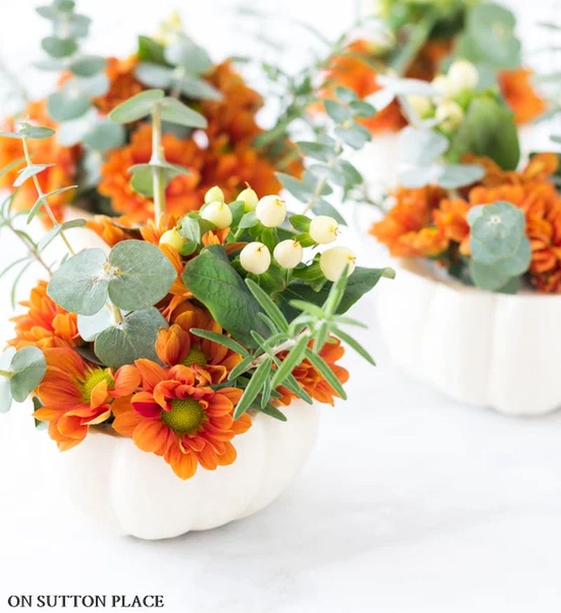 small pumpkin filled with a bunch of flowers 