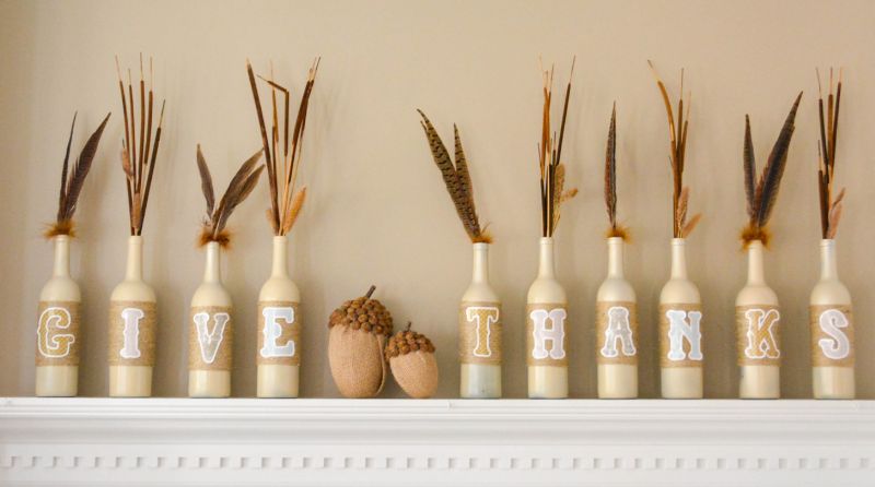 wine bottle decorated with paint and letters, feathers 