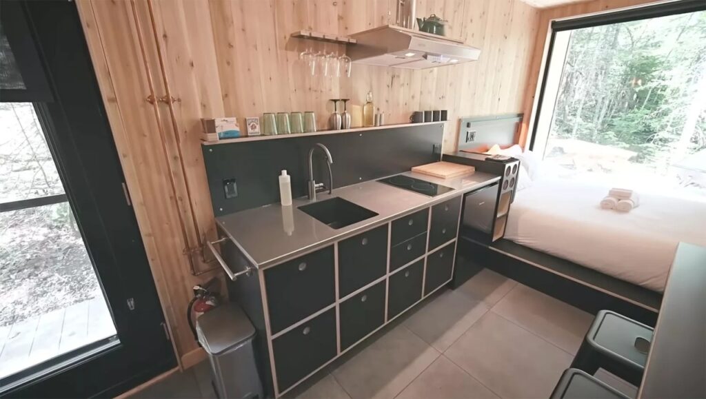 shipping container cabin kitchen with black cabinetry 