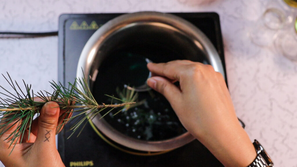 Add fresh pine needles and pine essential oil in the melted wax