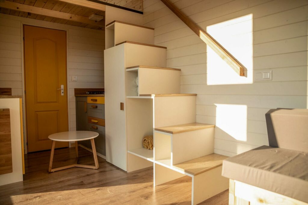 Riverside-Tiny-House-Compact kitchen under storage-integrated stairs