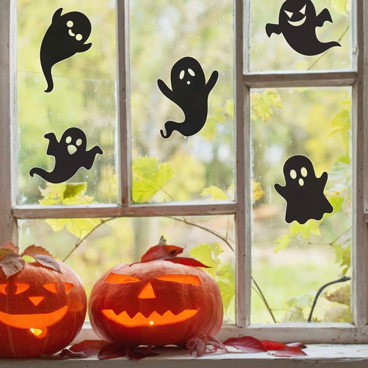 Cute ghost stickers with Jack-o-lanterns on window sill