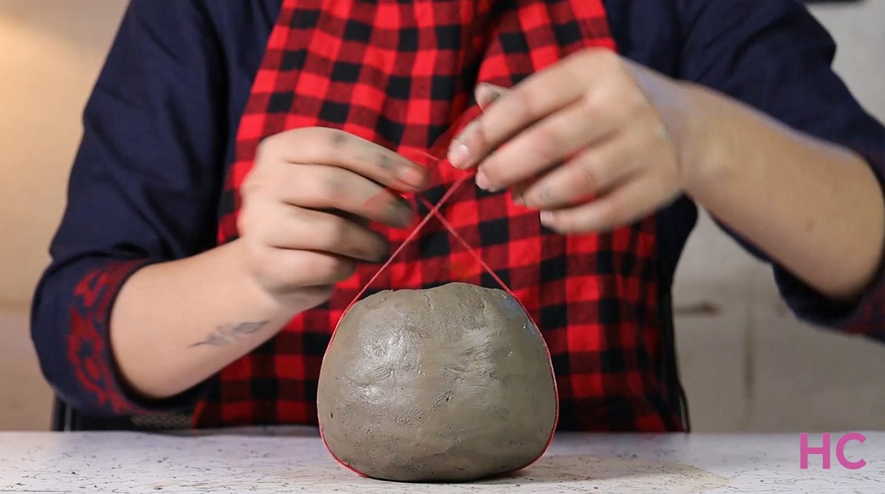 Jack-o-lantern clay candle holder - Tie the thread to make indentations