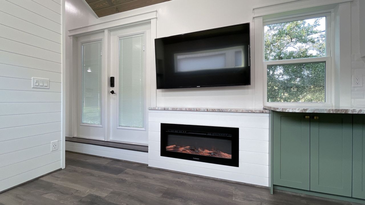 Manwaring tiny house interior featuring a tv and an electric fireplace