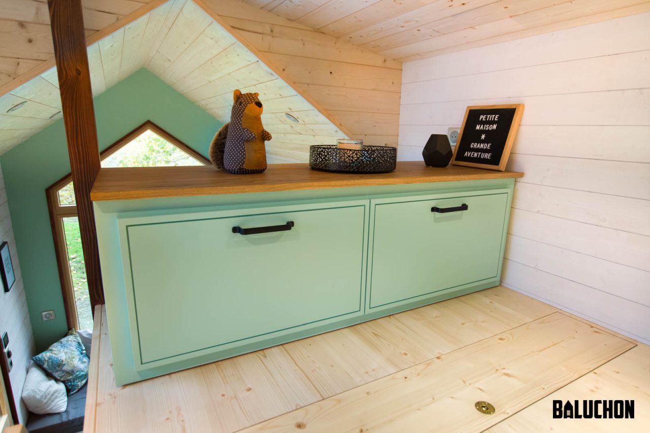 Storage cabinet in bedroom of Le Château Ambulant tiny house