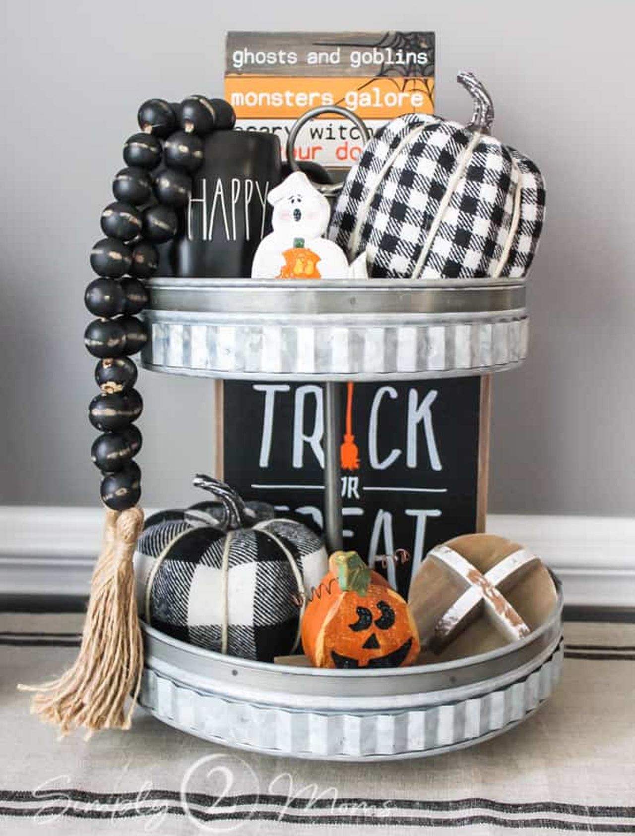 Farmhouse style Halloween tiered tray decor with signs and fabric pumpkin in plaid pattern
