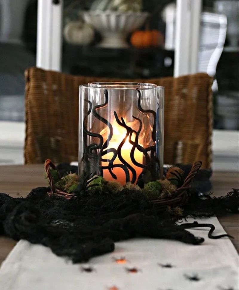 Make a quick DIY Halloween Centerpiece with plastic snakes, vases, and a candles